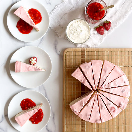 Vibrant 10 inch handcrafted Strawberry cheesecake topped with a creamy strawberry cream cheese icing , and three individually plated slices of strawberry cheesecake with homemade strawberry sauce