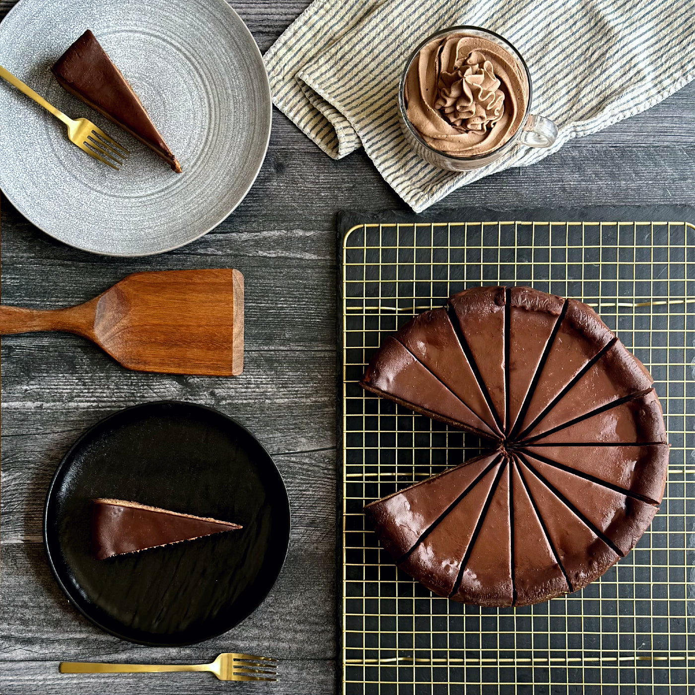 Perfectly sliced 10 inch handcrafted Triple Chocolate cheesecake, two individually plated slices of rich triple chocolate cheesecake, and a small bowl of fluffy chocolate whipped cream on the side