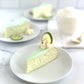 velvety slice of key lime cheesecake topped with a swirl of whipped cream and an elegant lime slice garnish