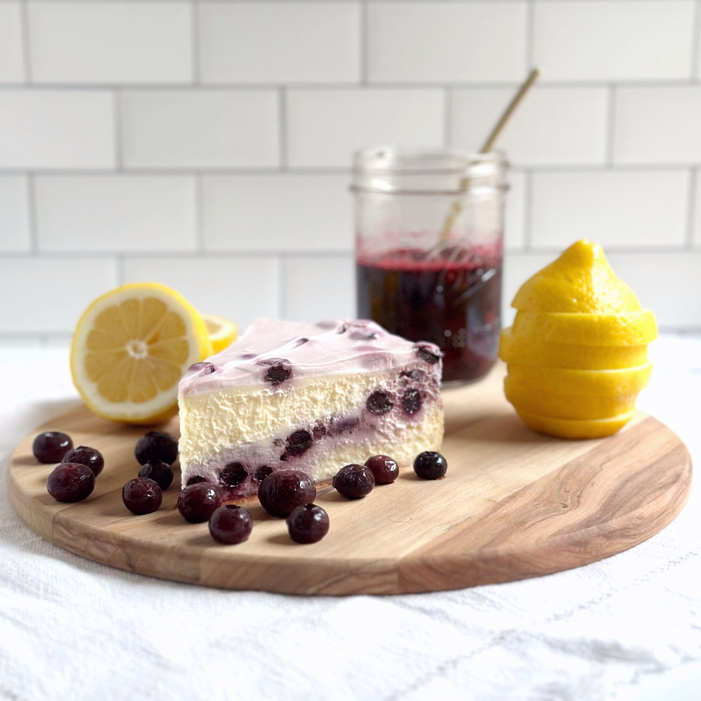 Velvety slices of Lemon Blueberry cheesecake with real blueberries baked-in and topped with a sweet blueberry cream cheese icing with real blueberries