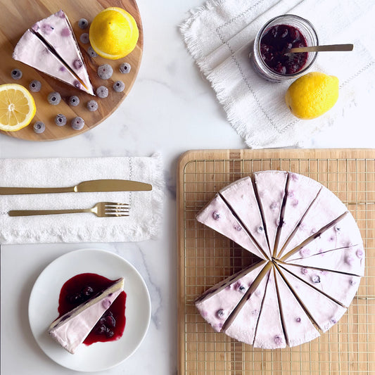 Delicious 10 inch handcrafted Lemon Blueberry cheesecake topped with a sweet blueberry cream cheese icing , and three slices of lemon blueberry cheesecake with homemade blueberry compote