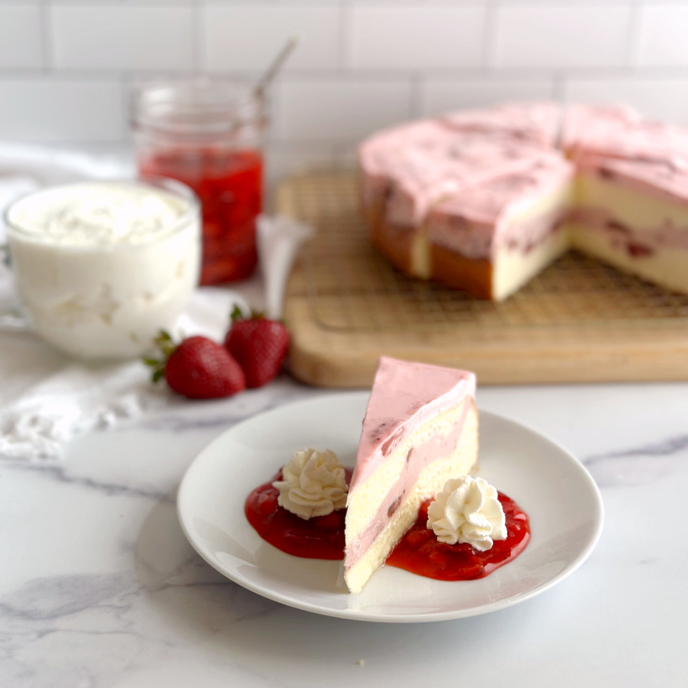 Velvety slice of Strawberry cheesecake served with a vibrant homemade strawberry sauce and a swirl of whipped cream